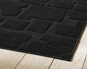 Large Ashley Furniture Gibbswell washable area rug in 8' x 10' size with intricate pattern and soft texture.