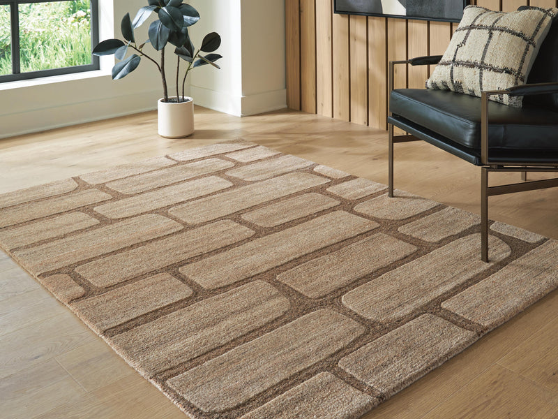 Close-up of the Ashley Furniture Orest Rug featuring a textured, patterned design in neutral tones, cropped for detail.