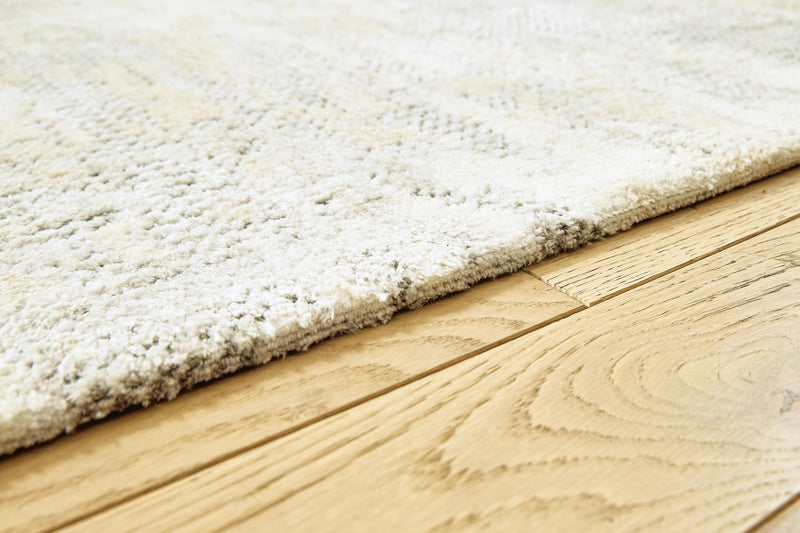 Close-up of Ashley Furniture Raif Rug showcasing its textured woven pattern and neutral color palette.
