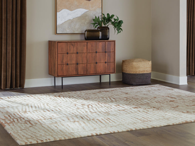 Ashley Furniture Uduak Rug with intricate geometric patterns in warm neutral tones, perfect for cozy living spaces.
