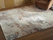 Ashley Furniture Jadenburg rug with a textured, patterned design in neutral tones, suitable for living rooms or bedrooms.