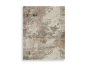 Ashley Furniture Jadenburg Rug with intricate pattern and warm tones, perfect for adding style to living room or bedroom decor.