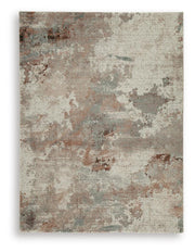 Ashley Furniture Jadenburg Rug with intricate patterns in warm tones, showcasing a soft, woven textile ideal for living room decor.
