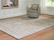 Ashley Furniture Eljory rug in a cropped view, showcasing its textured pattern and neutral color for living room decor.