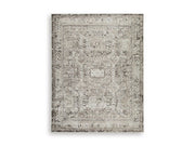 Ashley Furniture Junley Rug featuring a soft, patterned design in neutral tones, perfect for enhancing living room decor.
