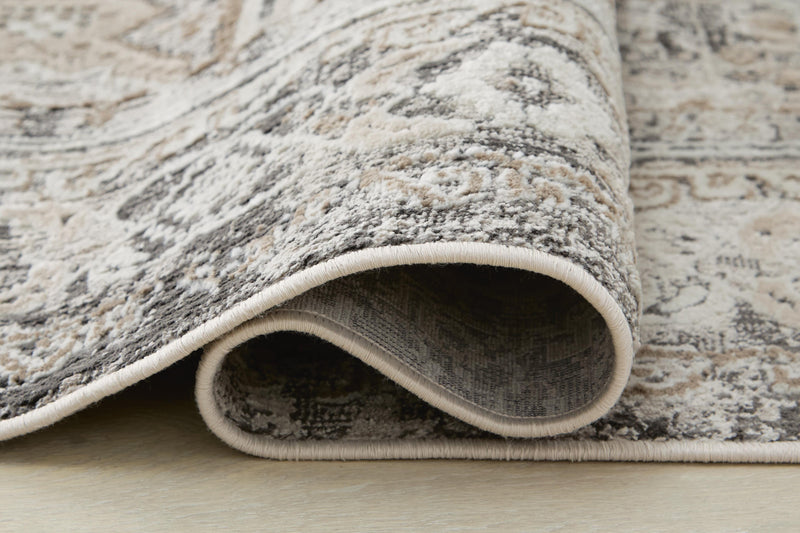 Close-up of the Ashley Furniture Junley Rug showing detailed woven texture and intricate patterns in neutral tones.