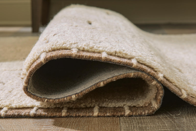 Close-up of Ashley Furniture Clayman Rug showing detailed woven texture and earthy color tones.