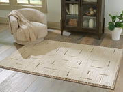 Ashley Furniture Clayman Rug with a textured design, featuring warm neutral tones and a soft pile, ideal for living room decor