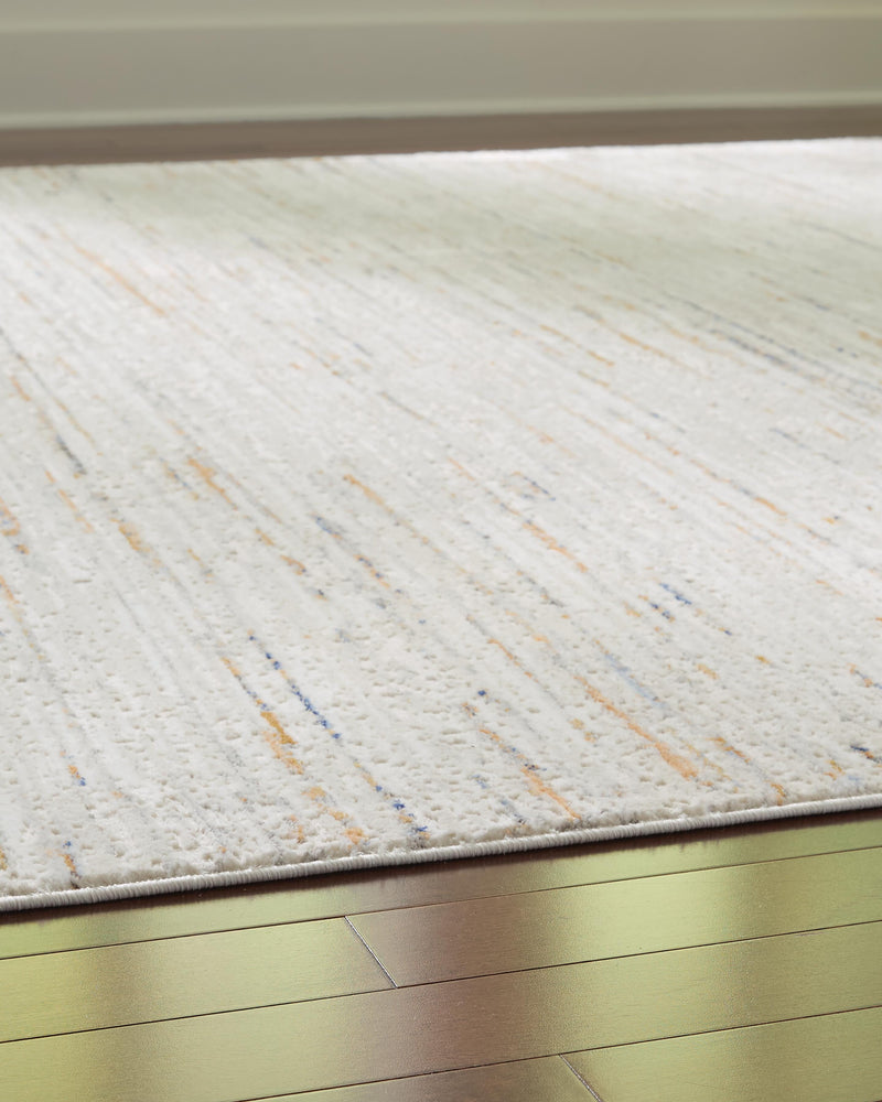 Close-up of the Ashley Furniture Harjot Rug showing its intricate woven pattern and soft texture on a neutral background.