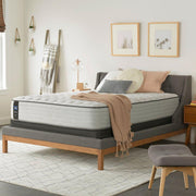 Sealy Garner II innerspring mattress with plush top layer, showing a neatly made bed with white sheets and pillows.