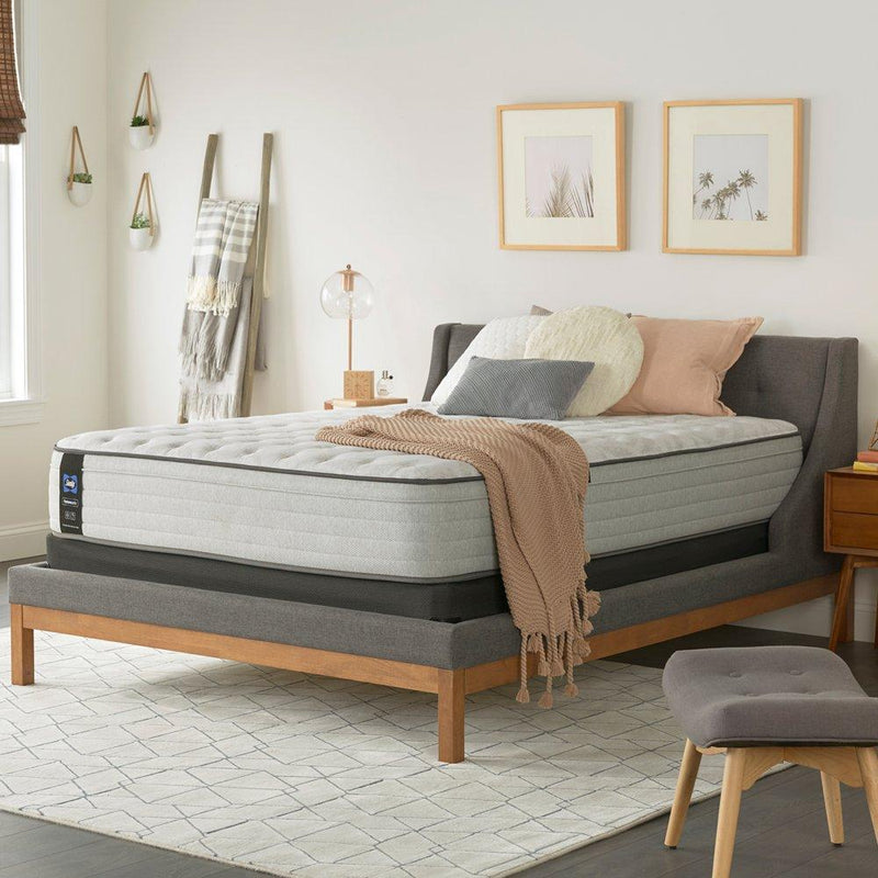 Sealy Garner II innerspring mattress with plush top layer, showing a neatly made bed with white sheets and pillows.