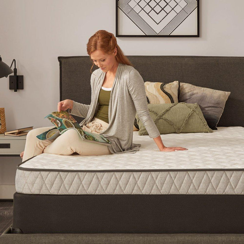 Sealy Spruce Innerspring Mattress showing a neatly made bed with white bedding and the mattress top visible.
