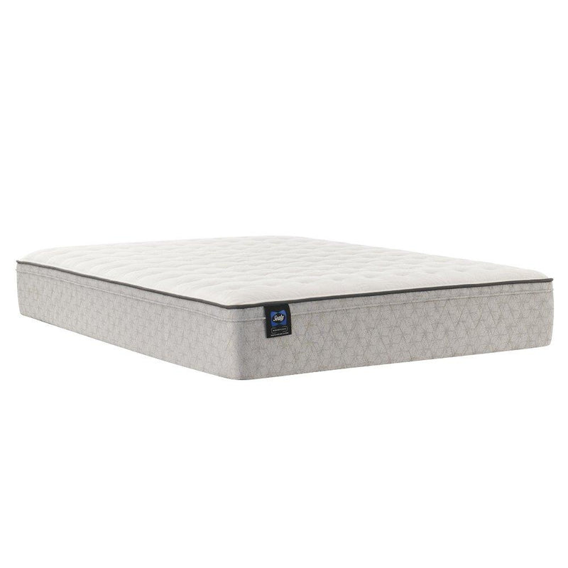 Sealy innerspring mattress with a quilted top and supportive layers, shown on a bed frame in a well-lit bedroom setting.