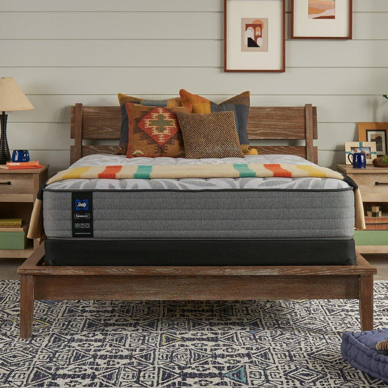 Sealy Philben innerspring mattress with quilted top and supportive coils, shown rolled out on a bed frame for comfortable sleeping.