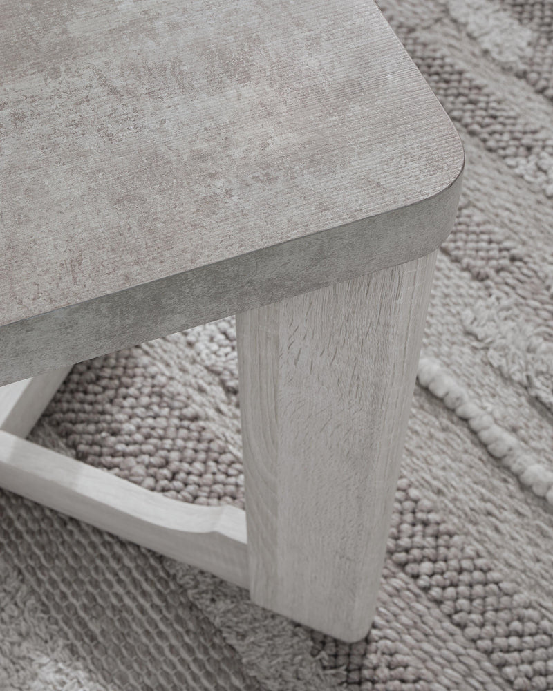 Set of three Garnilly Ashley Furniture end tables with wood finish and modern design, shown in a living room setting.