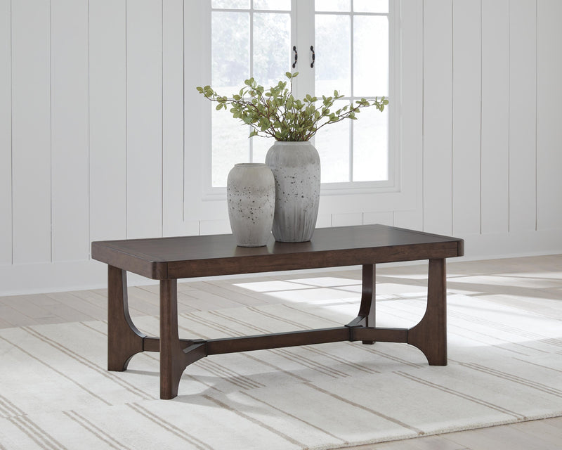 Ashley Furniture Korestone living room occasional table set with three modern, round tables featuring wood and metal finishes.