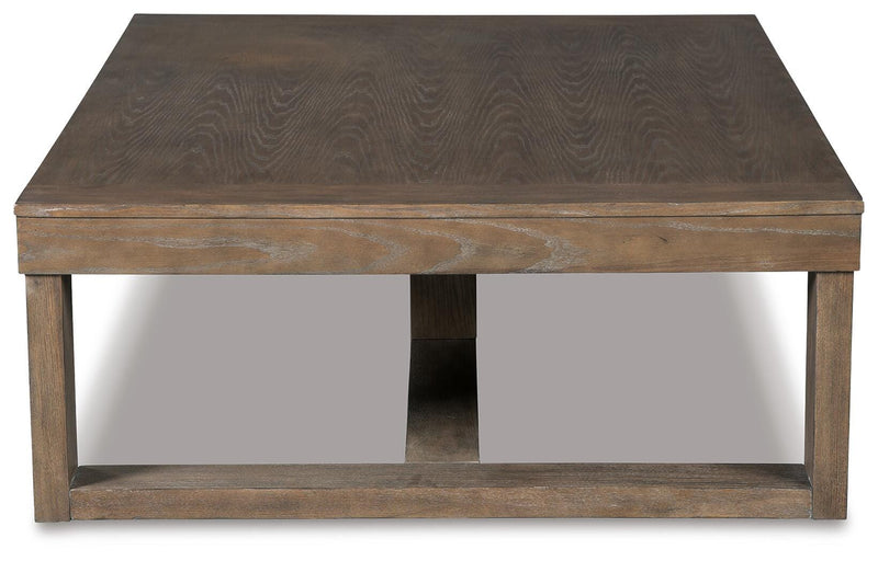 Ashley Furniture Cariton cocktail coffee table with a sleek wooden top and black metal legs, shown from a side angle.