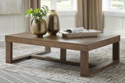 Ashley Furniture Cariton coffee cocktail table with a sleek wooden top and metal frame, shown in a modern living room setting.