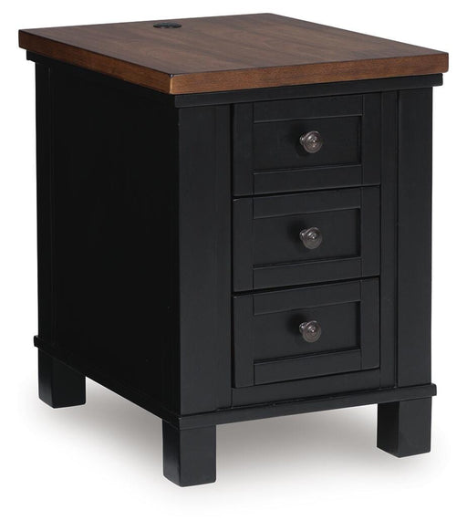 Ashley Furniture Wildenauer chairside end table with a dark wood finish and compact design, shown from an angled side view.