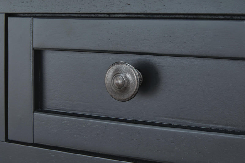 Close-up of Ashley Furniture Wildenauer End Table showing its wood grain surface and decorative metal knob detail.