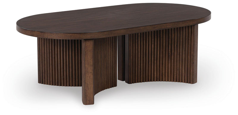 Ashley Furniture Korestone coffee table, modern cocktail table with a sleek surface and sturdy wooden legs, viewed from an angle.
