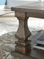 Ashley Furniture Johnelle coffee table, cocktail style with a polished wood surface and sturdy legs, stylish living room centerpiece.