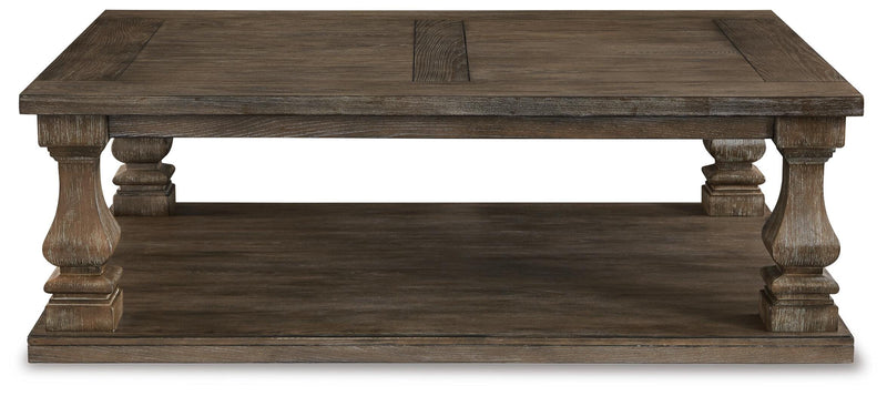 Ashley Furniture Johnelle cocktail coffee table with a sleek wooden top and sturdy metal legs, modern living room style.