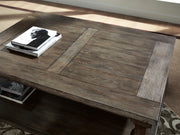 Ashley Furniture Johnelle cocktail coffee table with a wooden top and sleek design, perfect for living room decor.