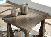 Ashley Furniture Johnelle Occasional Table Set featuring a stylish table with a wood finish and modern design.