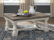 Ashley Furniture Havalance coffee table with a sleek wooden top and metal legs, serving as a stylish cocktail table.