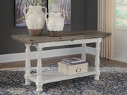 Ashley Furniture Havalance sofa table featuring a sleek design with a dark wood finish, perfect for living room decor.