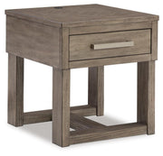 Ashley Furniture Loyaska occasional table set with three round wooden tables and tapered legs, shown from an angled view.
