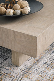 Ashley Furniture Jorlaina coffee cocktail table with a sleek wood finish and modern design, shown from a detailed angle.