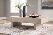 Ashley Furniture Jorlaina coffee cocktail table with a wooden finish and modern design, shown in a stylish living room setting.