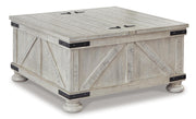 Ashley Furniture Carynhurst occasional table set with three wooden tables, shown from an angled view with closed storage compartments.