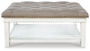 Ashley Furniture Kanwyn upholstered cocktail ottoman with padded top and wooden legs, used as a versatile coffee table.