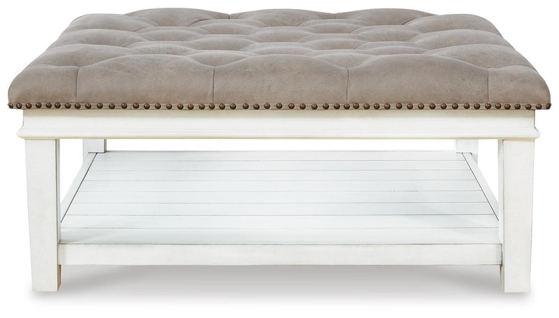 Ashley Furniture Kanwyn upholstered cocktail ottoman with padded top and wooden legs, used as a versatile coffee table.