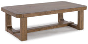 Ashley Furniture Cabalynn cocktail table with a sleek wooden top and metal legs, shown from an angled side view.