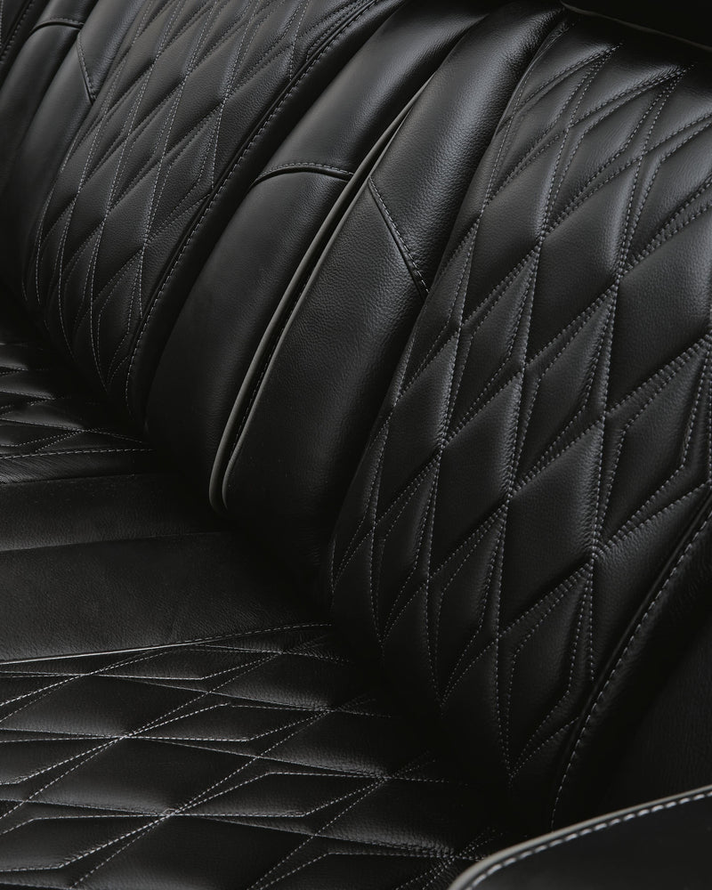 Ashley Furniture Boyington power reclining loveseat with diamond stitching, featuring a built-in console and plush cushioned seats.