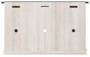 Ashley Furniture Dorrinson 54-inch TV stand with open shelving and dark wood finish, shown from the back with cable management holes.