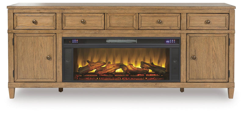 Ashley Furniture Sharlance 81-inch TV stand with electric fireplace, wood finish, and central display area, shown head-on.