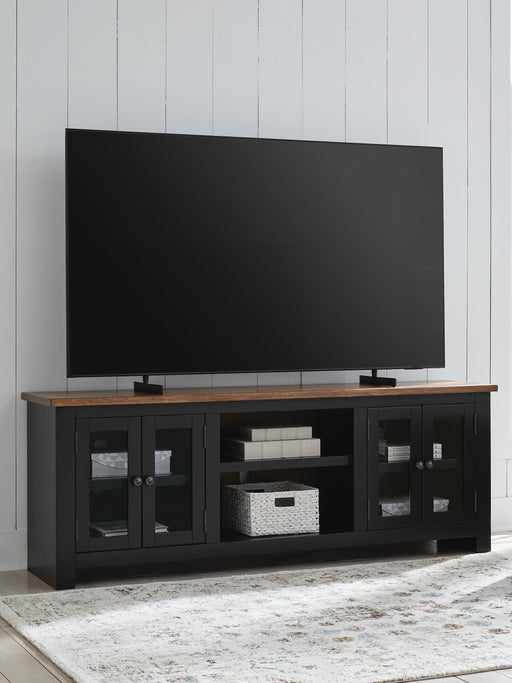 Wildenauer 76-inch TV stand by Ashley Furniture with open shelves and storage cabinets, in a dark wood finish.