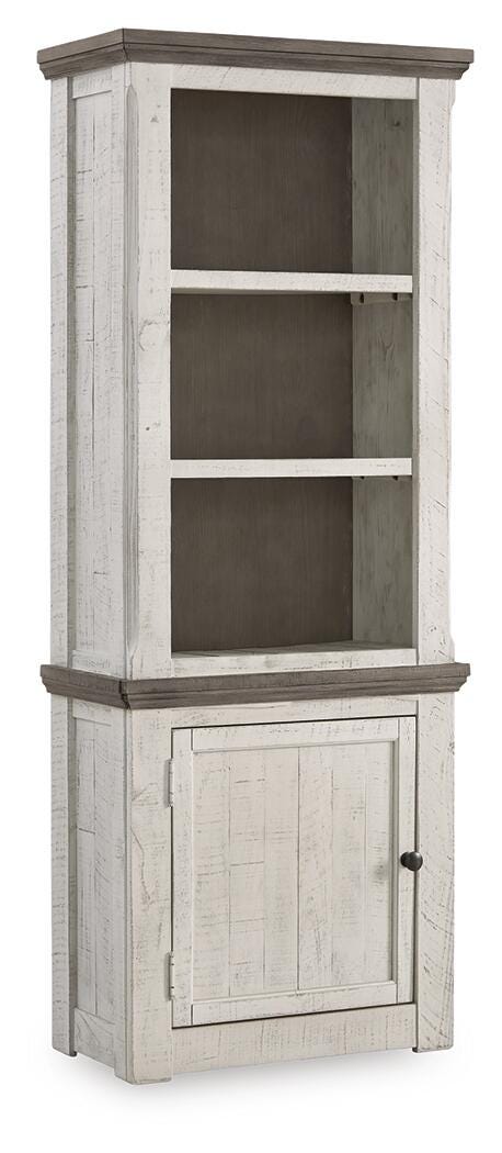 Ashley Furniture Havalance left pier cabinet with closed door, wooden finish, and decorative top detail.