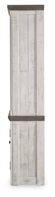 Ashley Furniture Havalance left pier cabinet with wood finish, featuring storage drawers and decorative design.