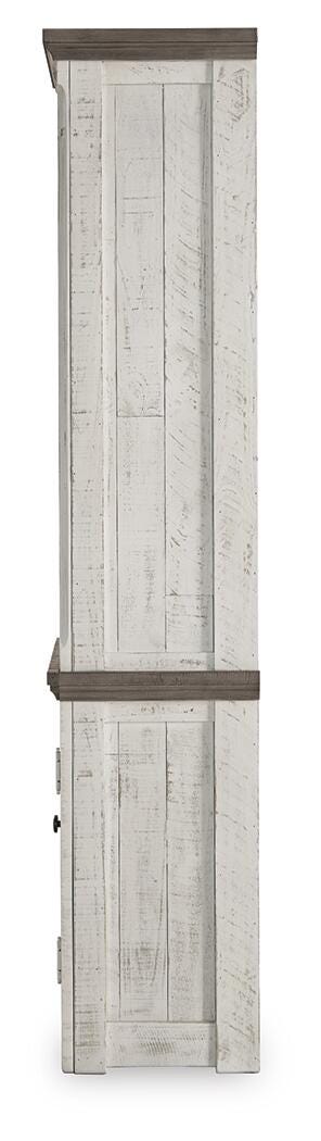 Ashley Furniture Havalance left pier cabinet with wood finish, featuring storage drawers and decorative design.