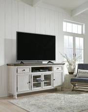 Ashley Furniture Havalance TV Stand with open shelves and storage cabinets, finished in a warm, rustic wood tone.